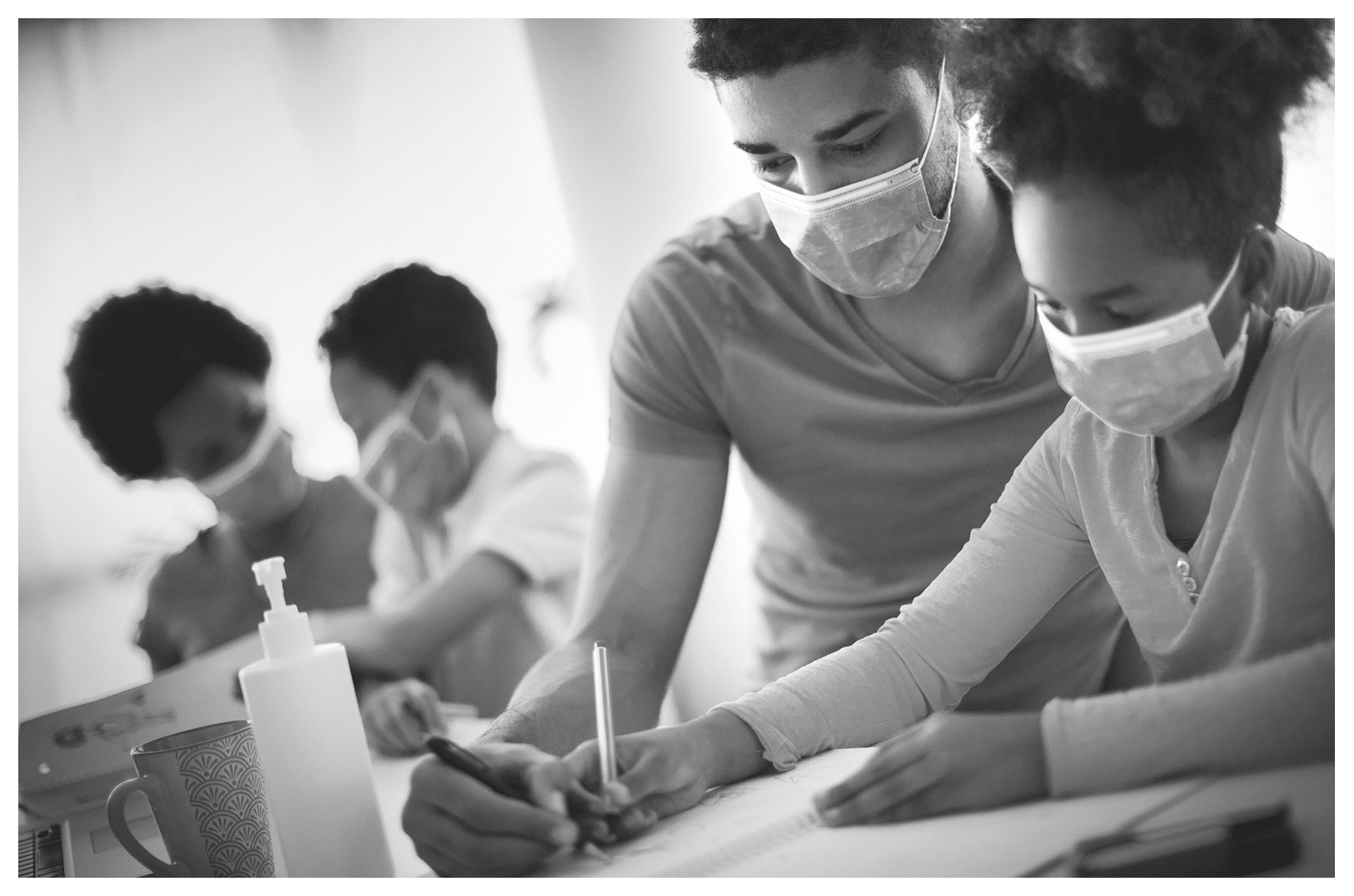 Two students and two tutors working together wearing masks
