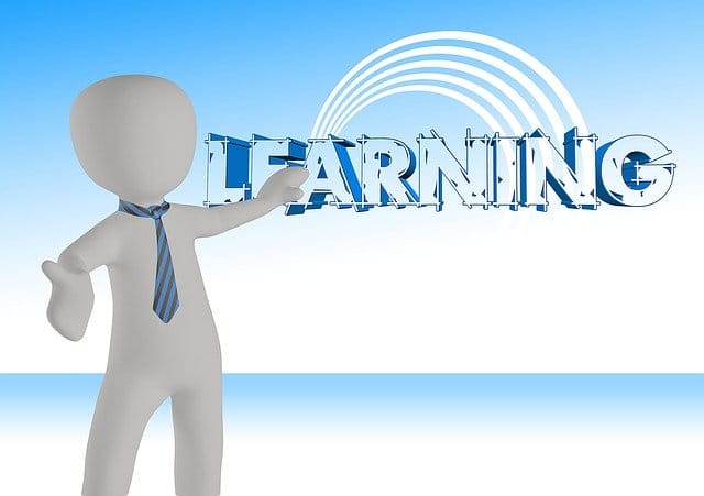 Depiction of business person partner pointing up to the word Learning